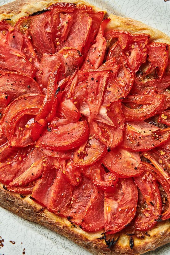 Pizza piled high with tomatoes.