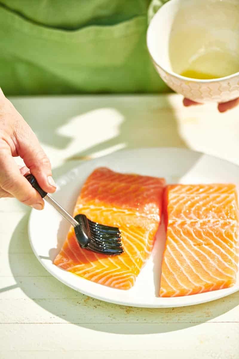 Brushing oil on salmon filets before grilling.