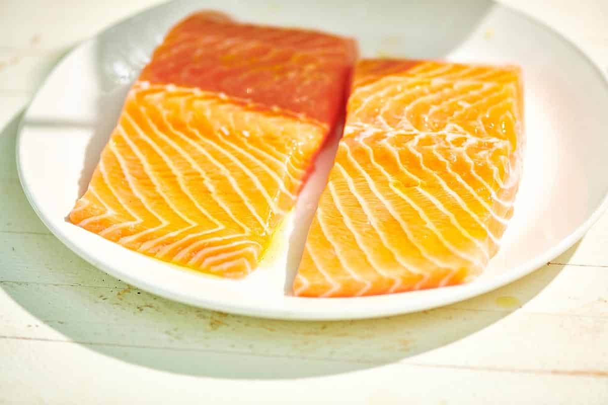 Fresh salmon filets on white plate.