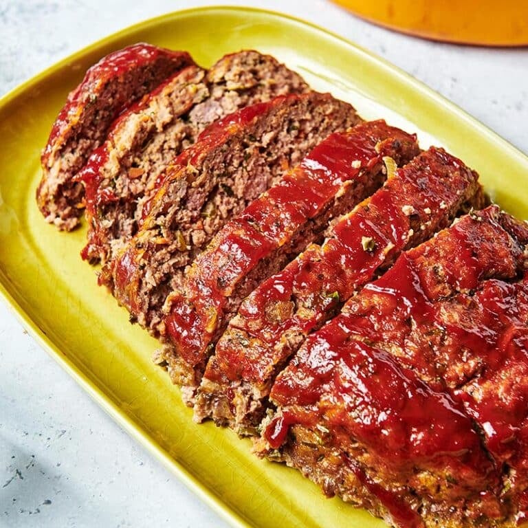 Sliced Meatloaf on a yellow-green dish.