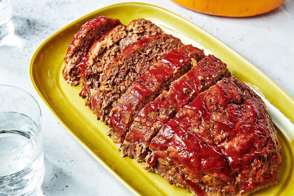 Sliced Meatloaf on a yellow-green dish.