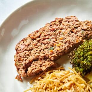 Meatloaf on a plate with broccoli and rice.