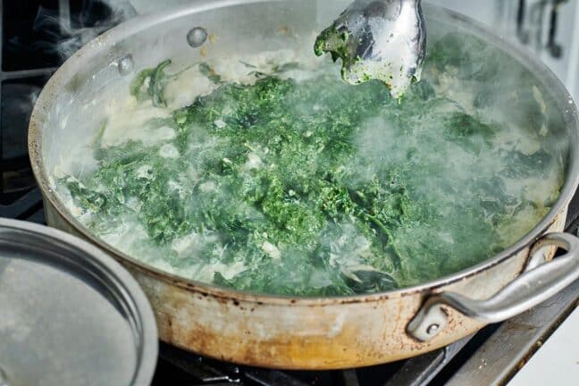Immersion blender over a steaming skillet of Creamed Spinach.
