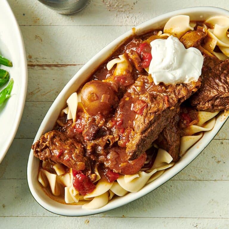 Hungarian Goulash and egg noodles in an oblong dish.