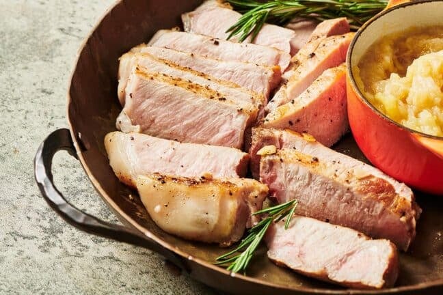 Slices of cooked pork chop in a pan.