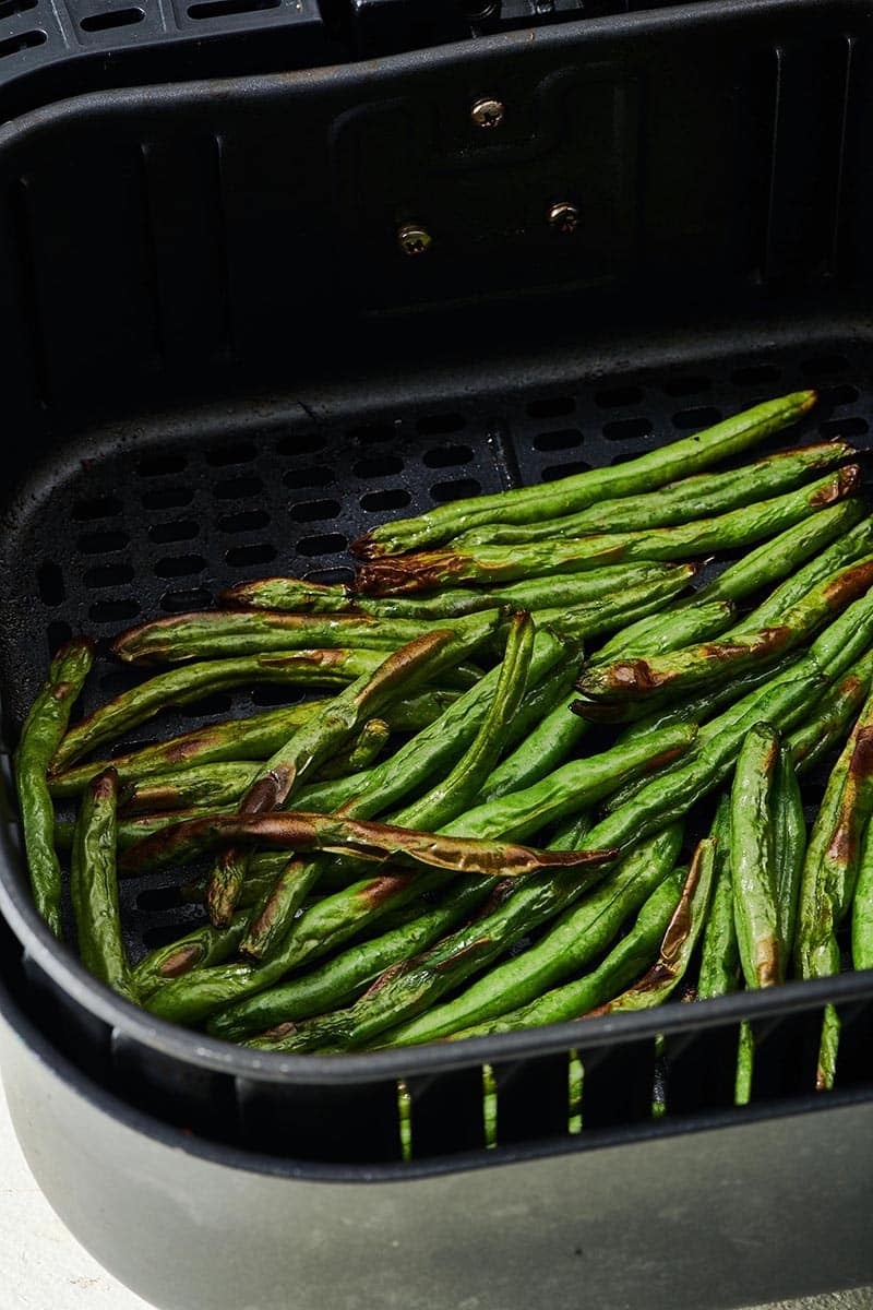 Green Beans in an air fryer basket.