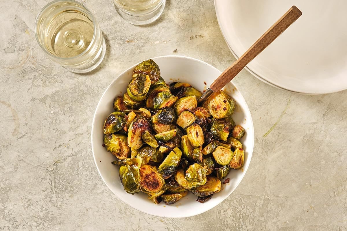 Chili Crunch Brussels Sprouts in a white serving bowl.