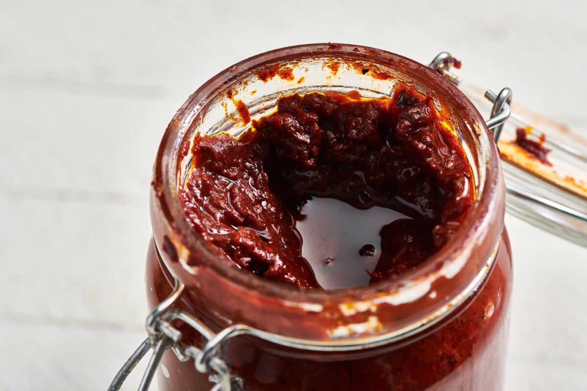 Harissa Sauce in a jar with the lid off.