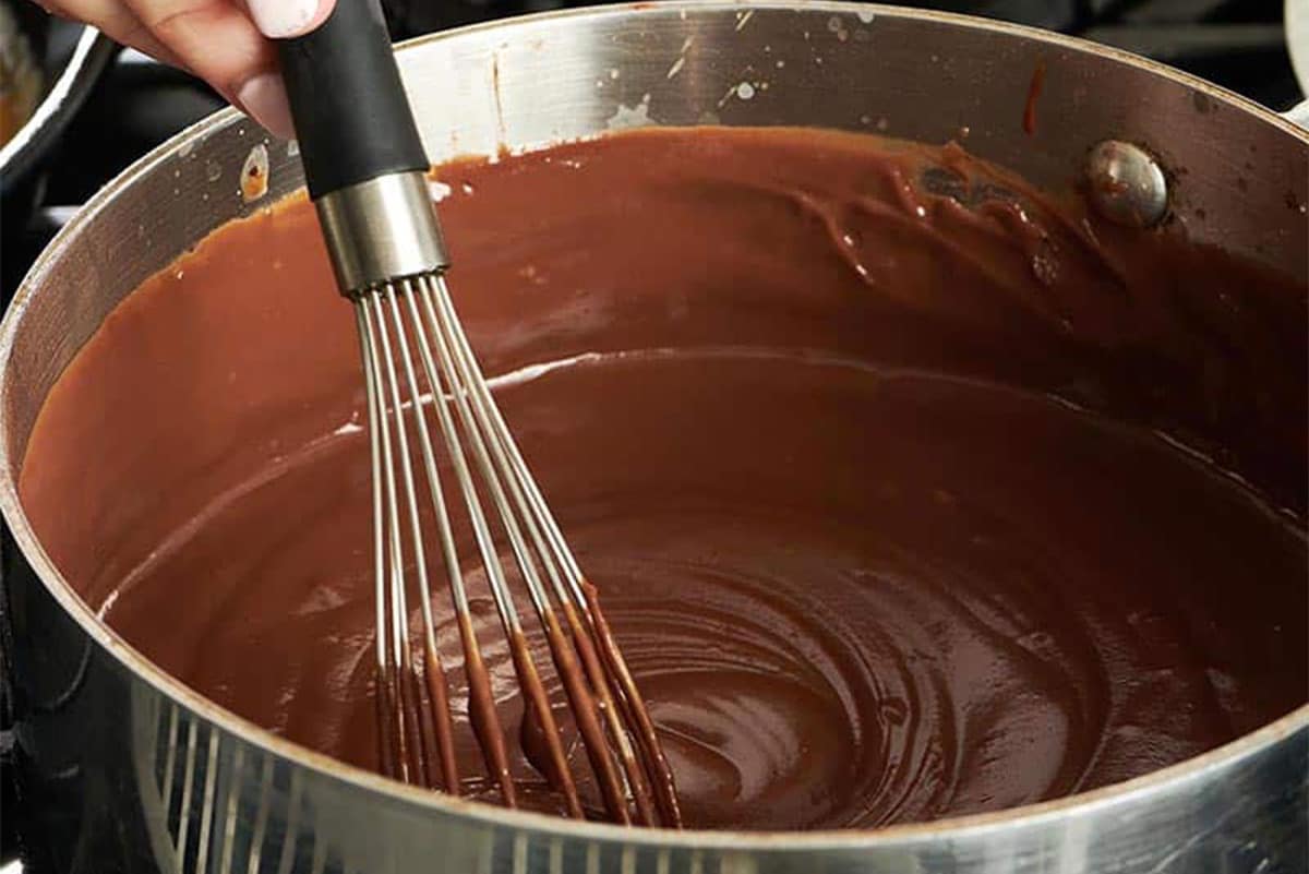 Woman whisking a pot of Chocolate Pudding.