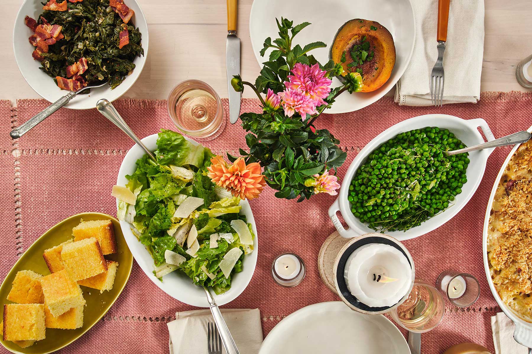Escarole Salad set on a table with flowers, bread, peas, and a candle.