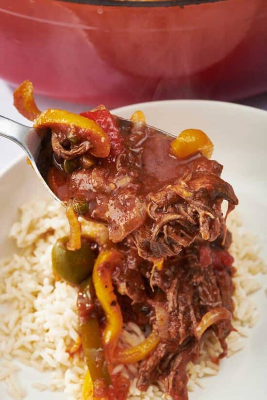 Fork grabbing Ropa Vieja from a bed of rice.