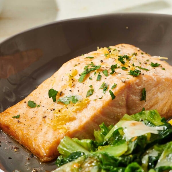 Salmon with Lemon Butter Sauce on brown plate with salad.