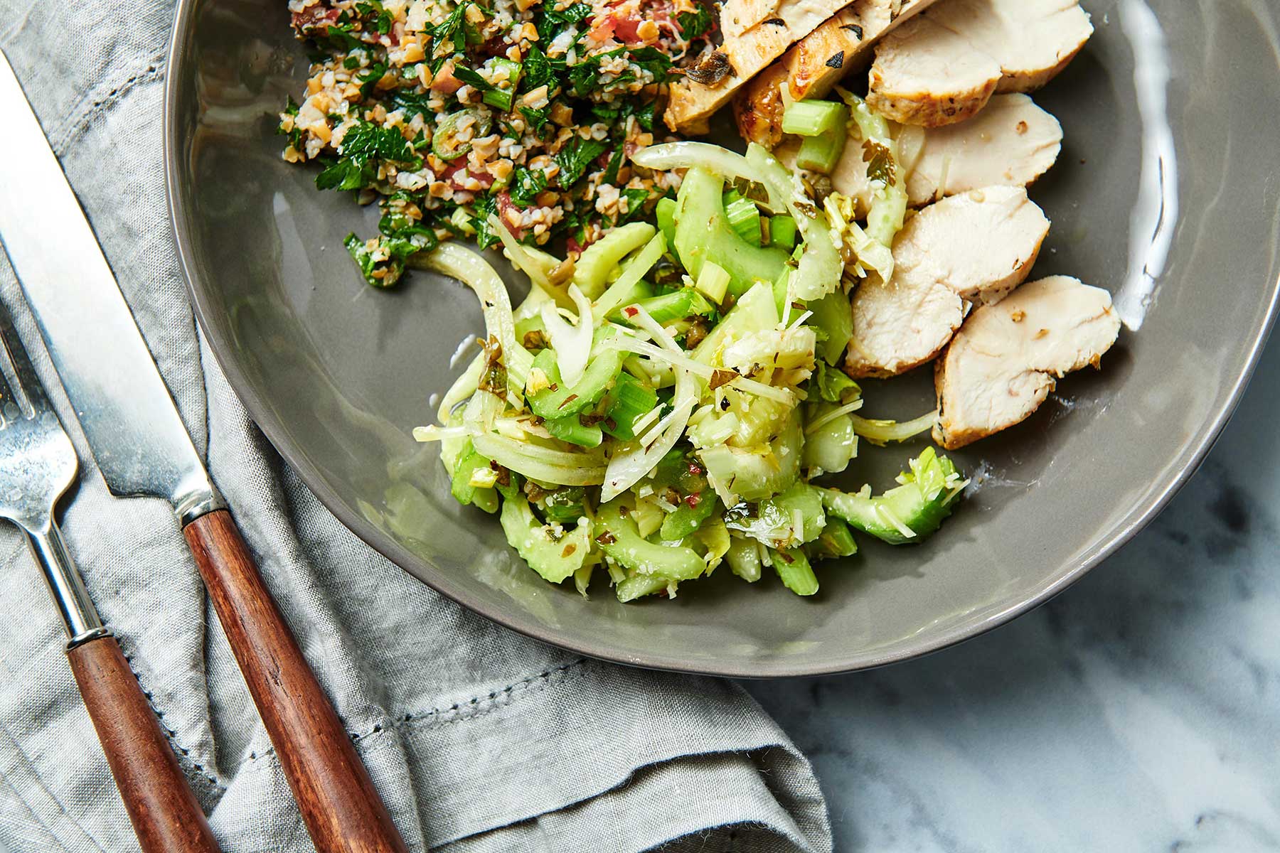 Celery Salad on grey plate with sliced chicken breast.