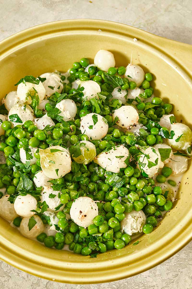 Creamed Peas and Pearl Onions in yellow bowl.