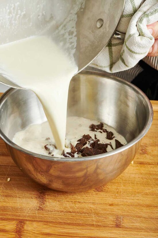 Pouring cream over chopped chocolate for ganache