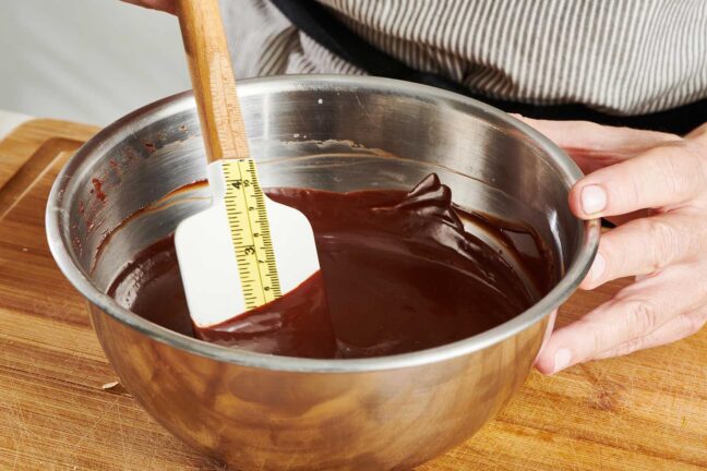 Stirring chocolate ganache in stainless steel bowl