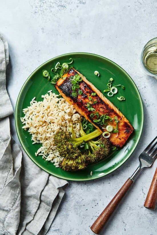 Miso Salmon with rice and broccoli on green plate