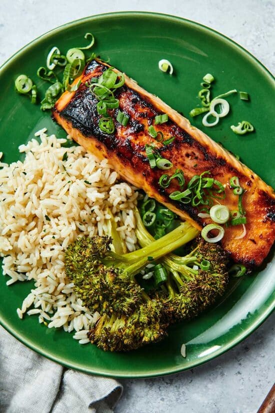 Broccoli, rice, and broiled miso salmon on green plate