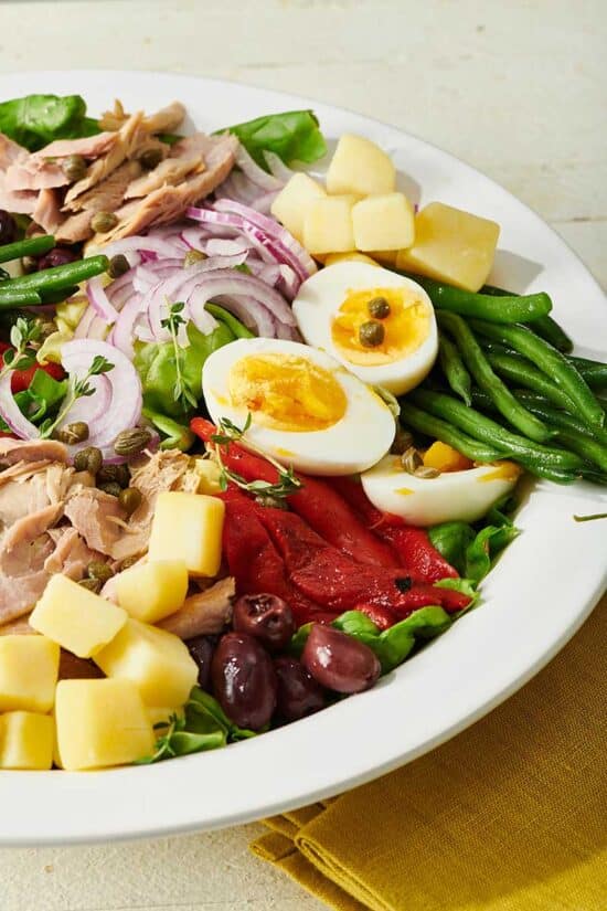 Nicoise Salad in serving bowl with eggs, olives, and cheese
