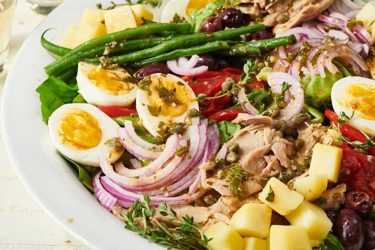 Colorful Nicoise Salad with red onion, asparagus, and hard-cooked eggs.