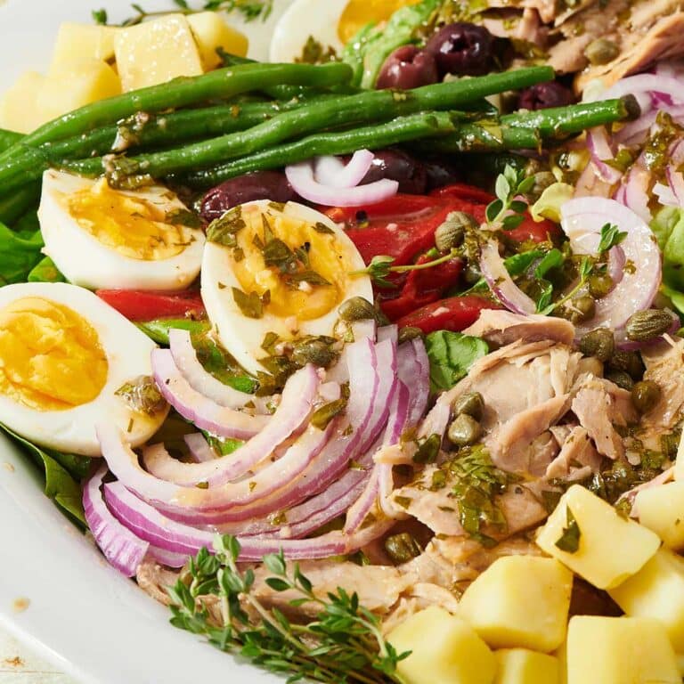 Colorful Nicoise Salad with red onion, asparagus, and hard-cooked eggs.