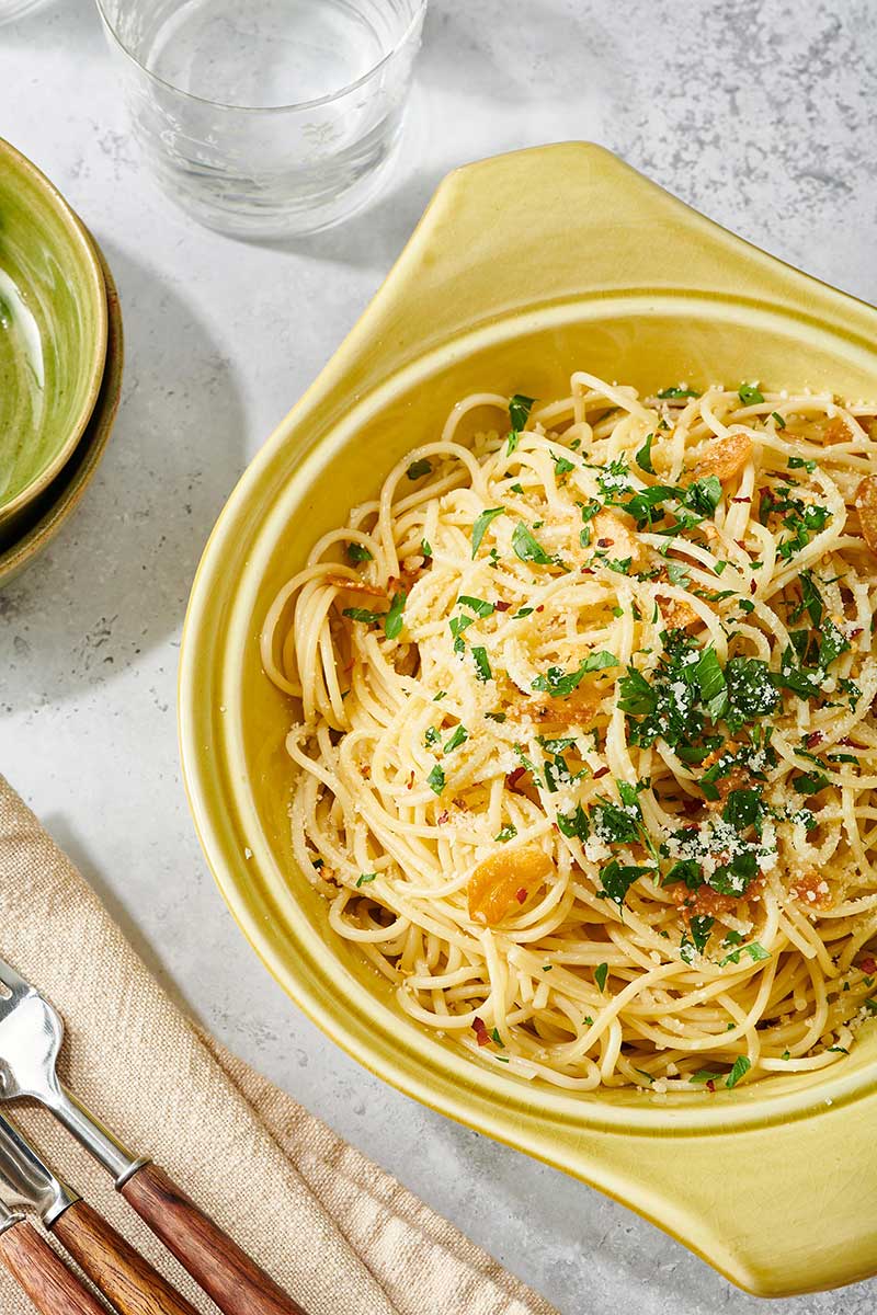 Pasta Aglio e Olio in yellow serving dish.
