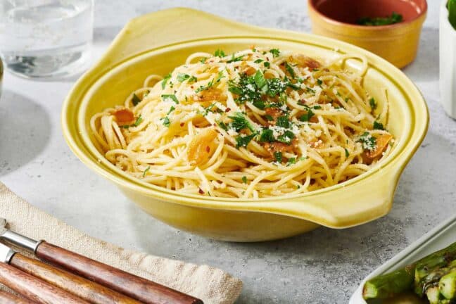 Pasta Aglio e Olio in yellow serving dish on table