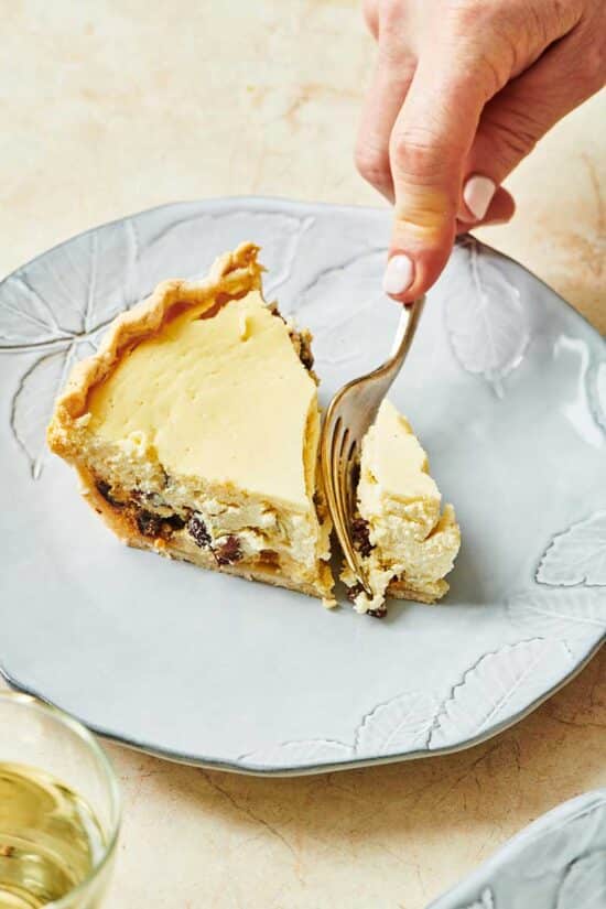 Cutting a slice of ricotta pie with fork