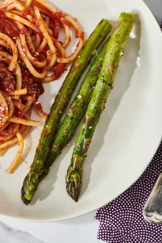 Plate of grilled lemon butter sauce asparagus and spaghetti