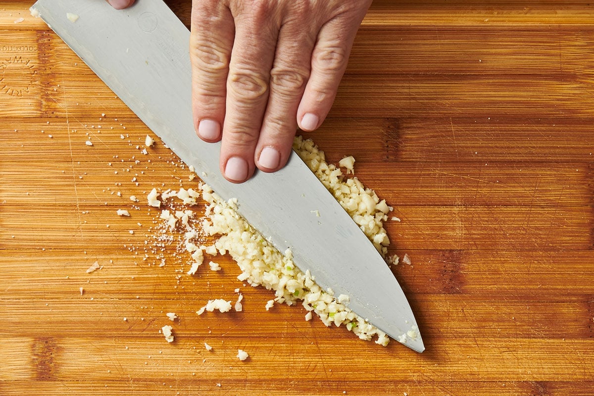 Mincing garlic with chef knife.