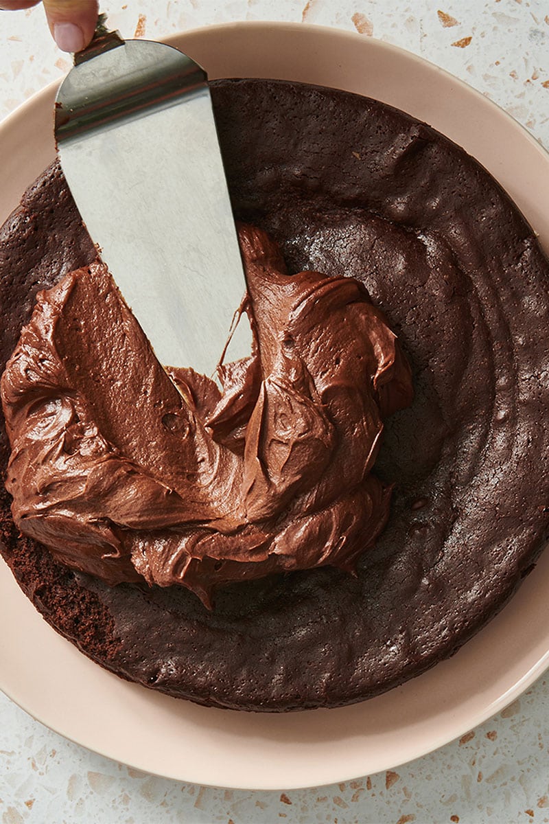 Spreading frosting on chocolate cake