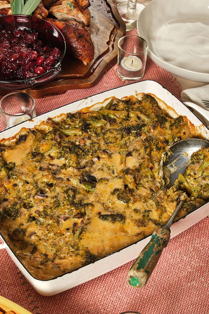 Broccoli casserole on table with cranberries.