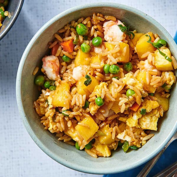 Pineapple Shrimp Fried Rice in blue bowl on table.