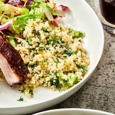 Quinoa salad on white plate with ribs