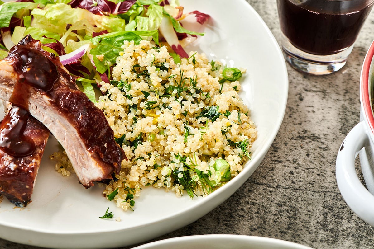 Quinoa salad on white plate with ribs