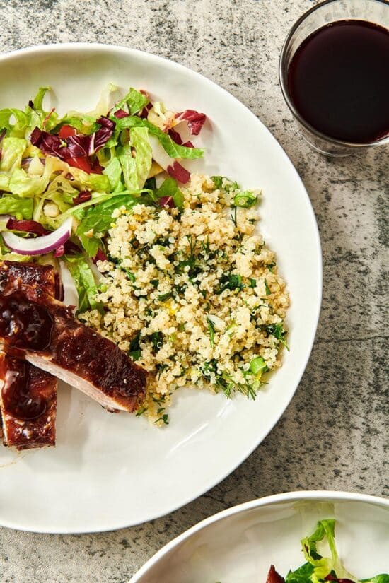Quinoa salad on plate with barbecue ribs and lettuce