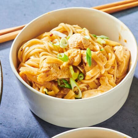 Bowl of Asian Stir-Fried Chicken and Rice Noodles with chopsticks