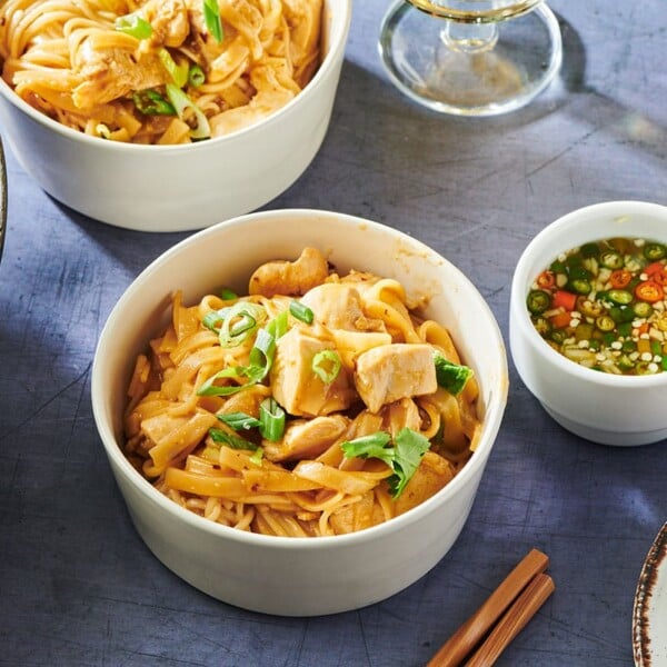 Bowls of Asian Stir-Fried Chicken and Rice Noodles on table