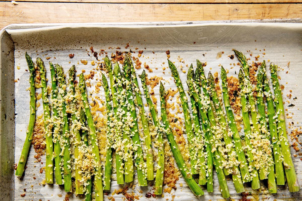Roasted asparagus with garlic and Parmesan on baking pan.