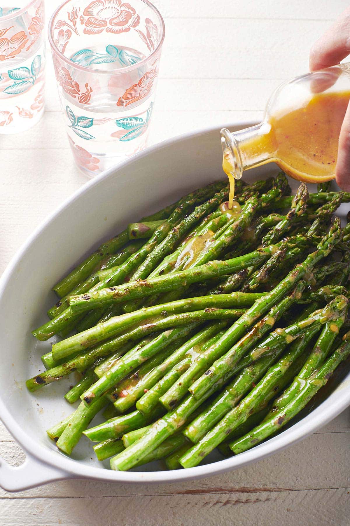 Grilled asparagus with vinaigrette Drizzling vinaigrette over Grilled Asparagus.