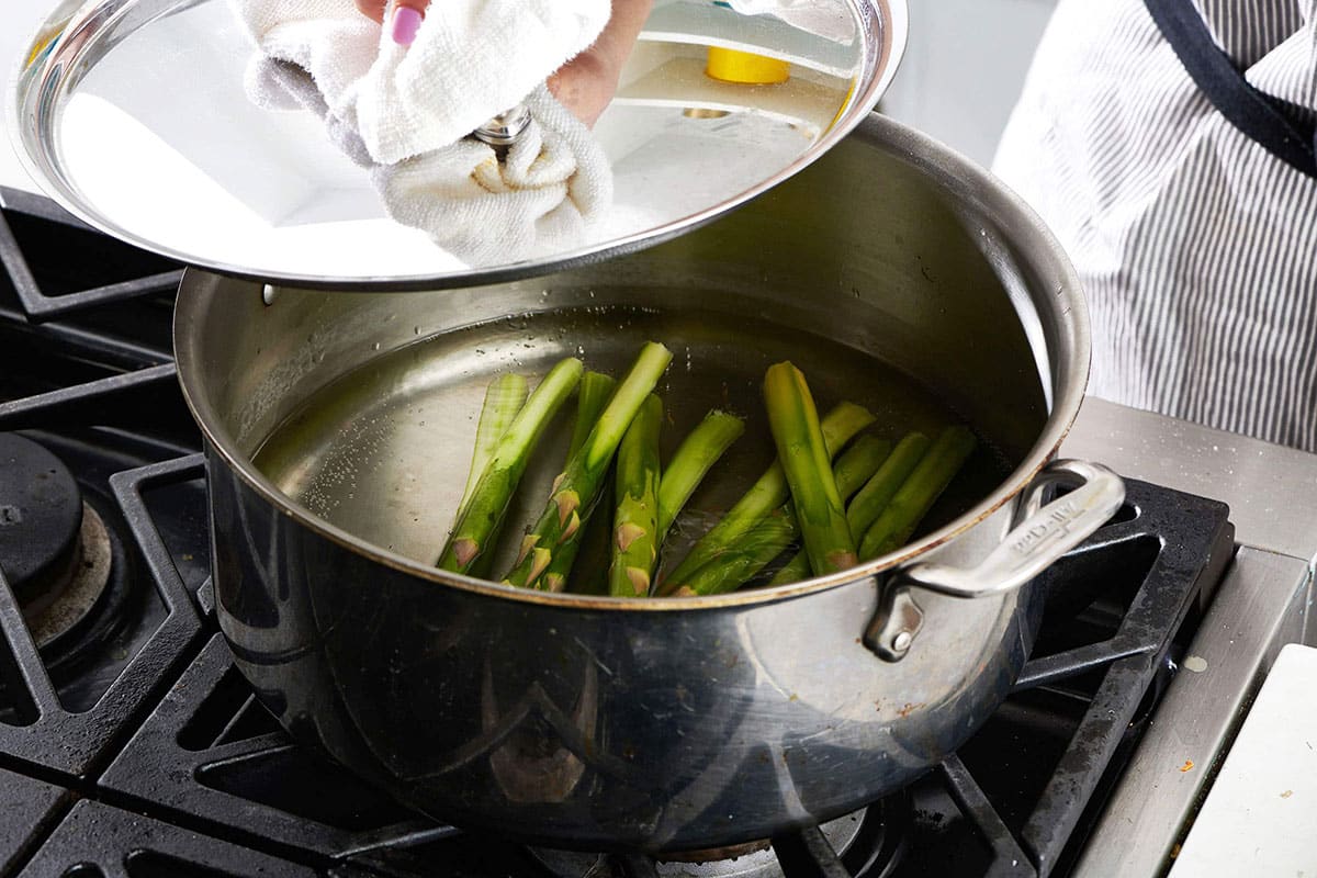 Blanching asparagus in pot of water on stove.
