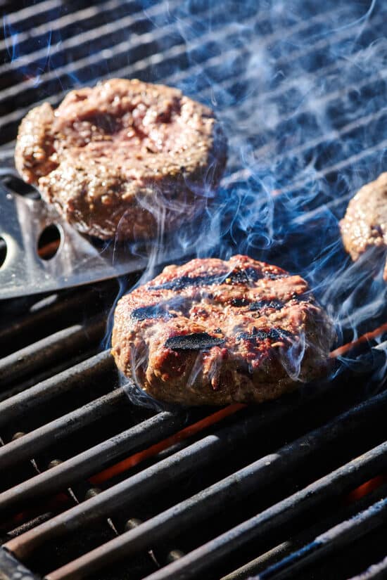Flipping burgers on the grill with a spatula.
