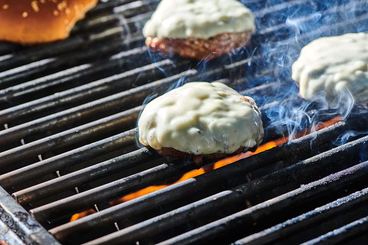 Cheese melting on grilled burgers.