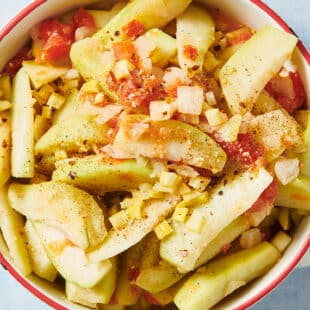 Stewed chayote with tomatoes and onions in white cooking pot