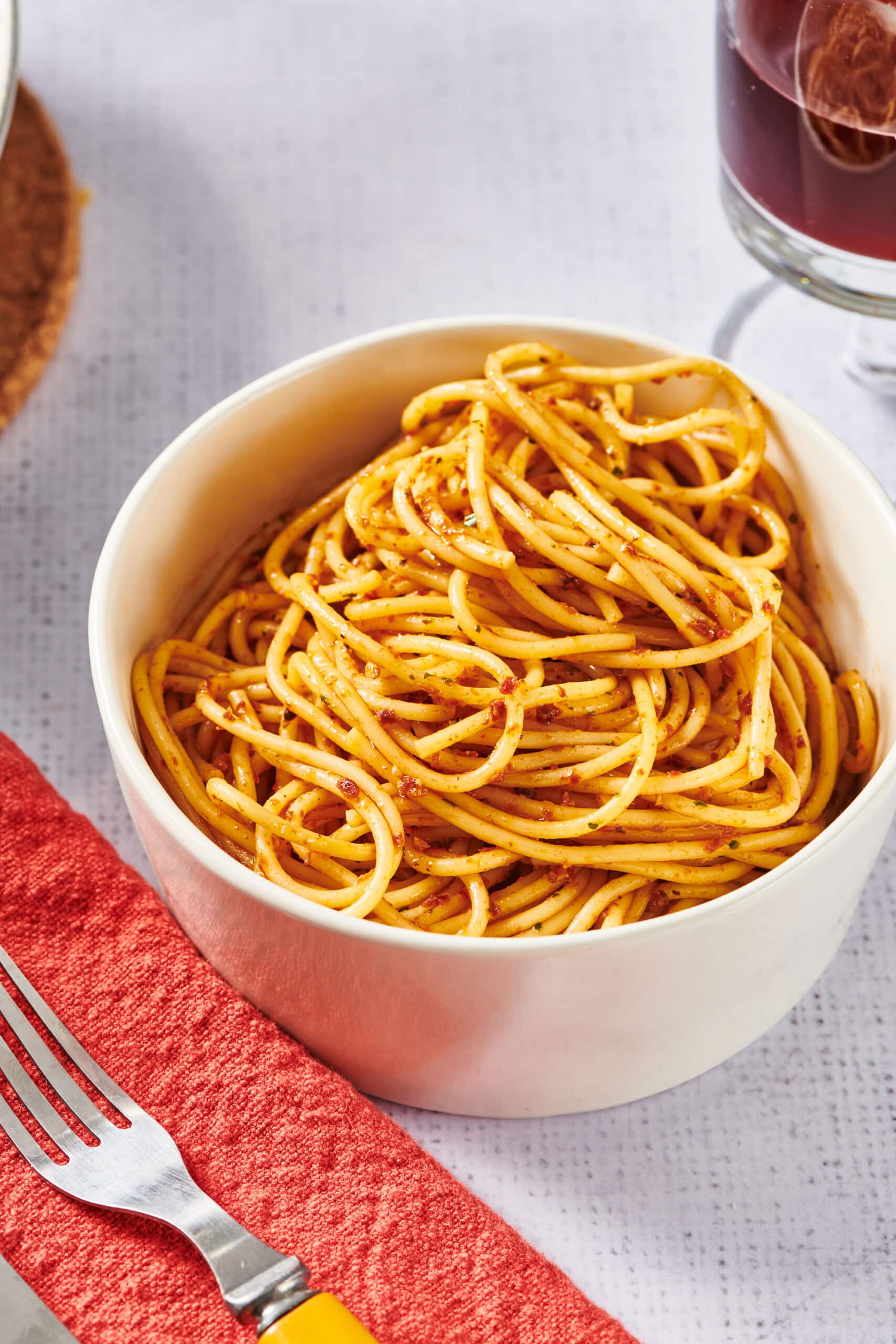 White bowl of sun-dried tomato pesto with spaghetti