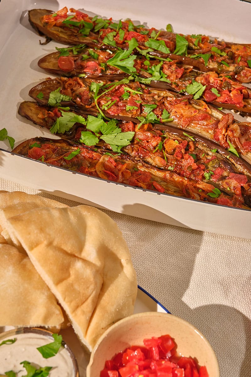 Stuffed Turkish eggplant (Imam Bilady) in a plate of bread and spices.