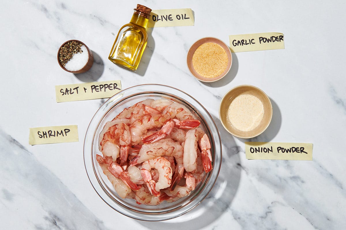 Raw shrimp, onion and garlic, and other ingredients for perfect air-fried shrimp.