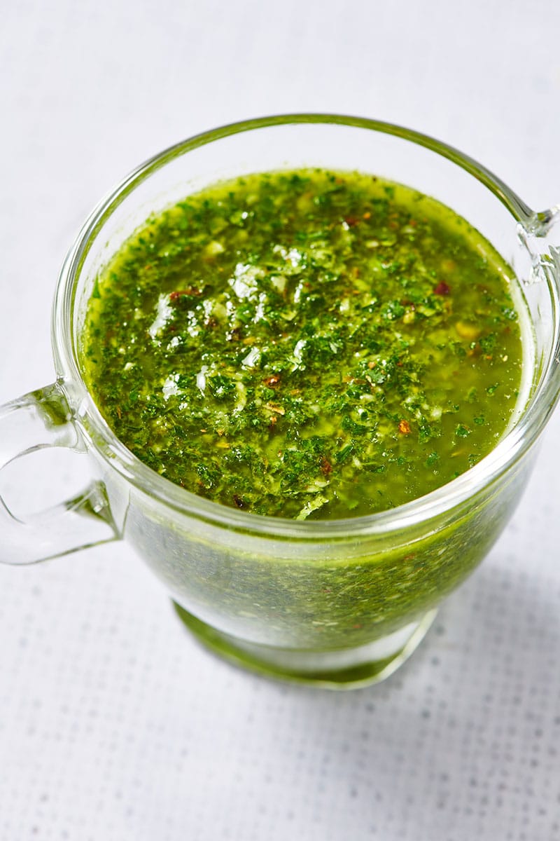 Glass jar filled with green Chimichurri Sauce.