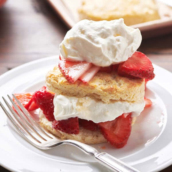 Plate with two repeating layers of biscuit, strawberries, and whipped cream.