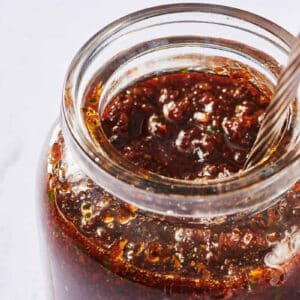 Jar of sun-dried tomato pesto with spoon.